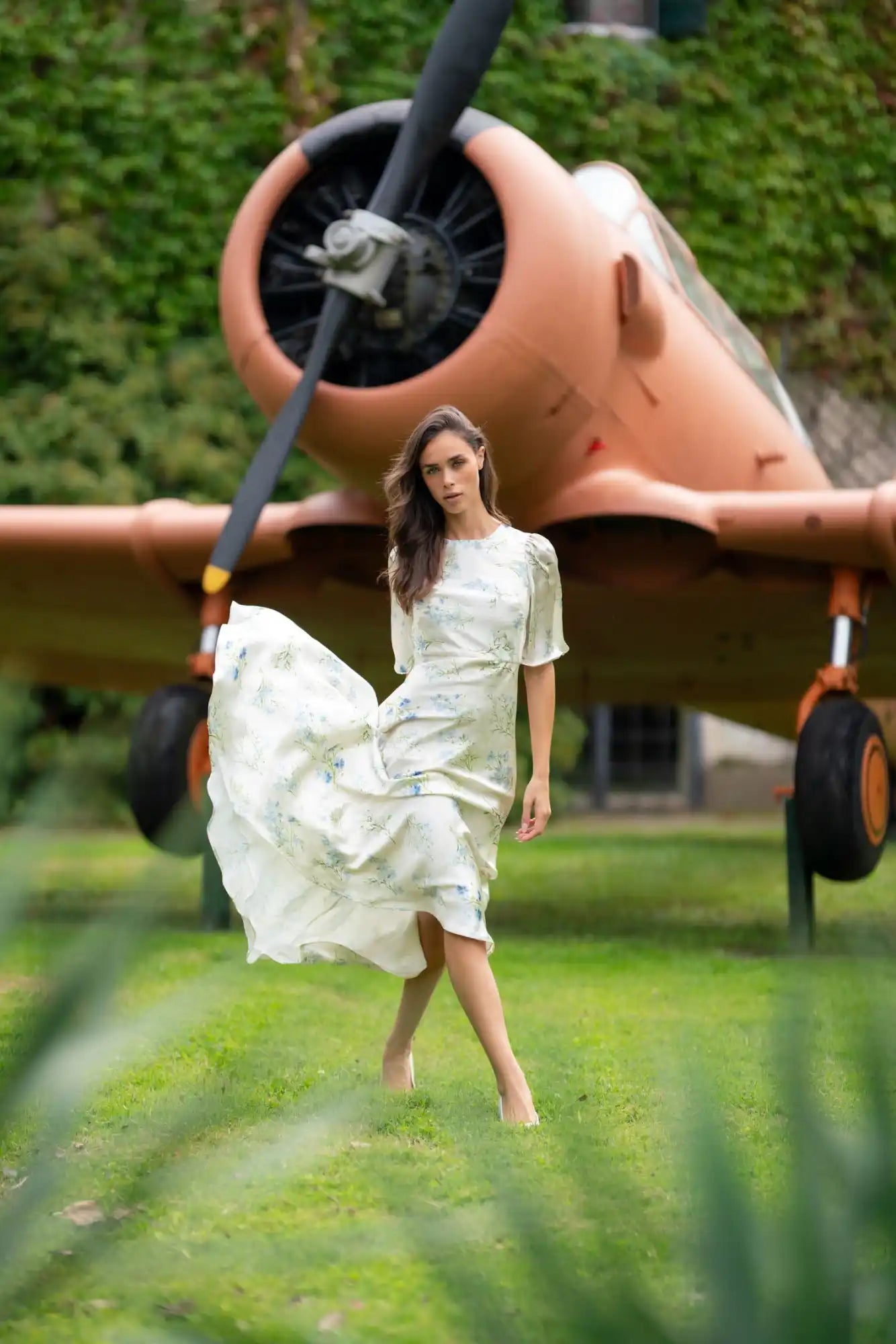 A woman in a flowing, light-colored dress with short sleeves.