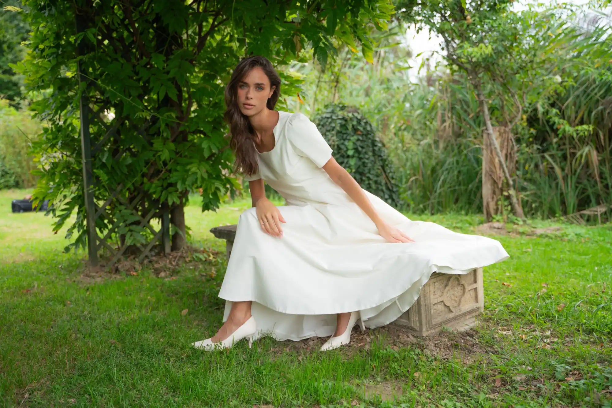 Woman in a flowing white dress and heels.